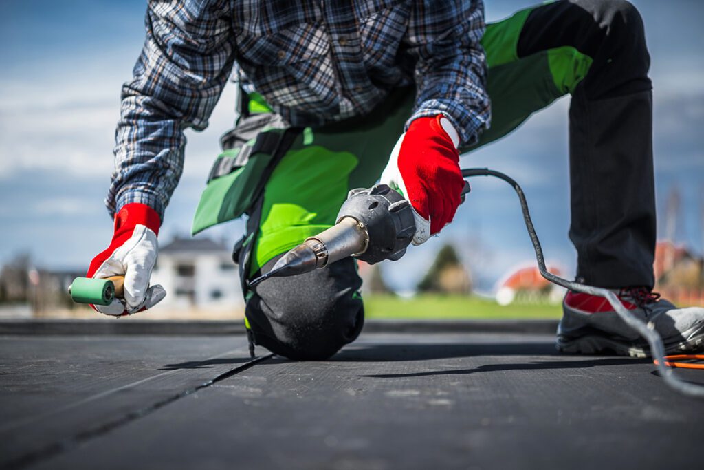 A roofing contractor using hot air to weld an EPDM seam.