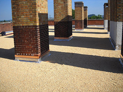 A flat roof with built-up roofing material and columns on it.