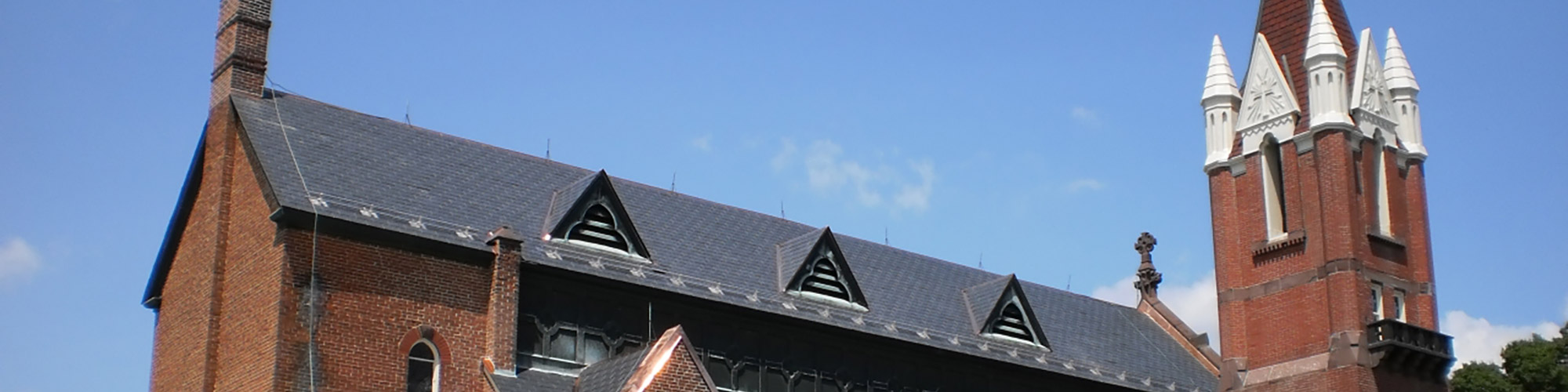 A church with a steep roof and a cemetery.