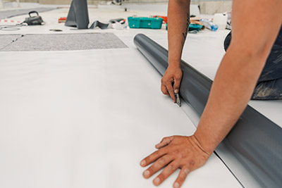 a person cutting TPO roofing