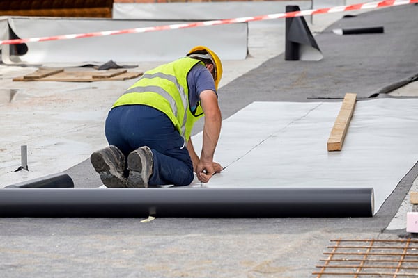 A roofer installing PVC roofing.