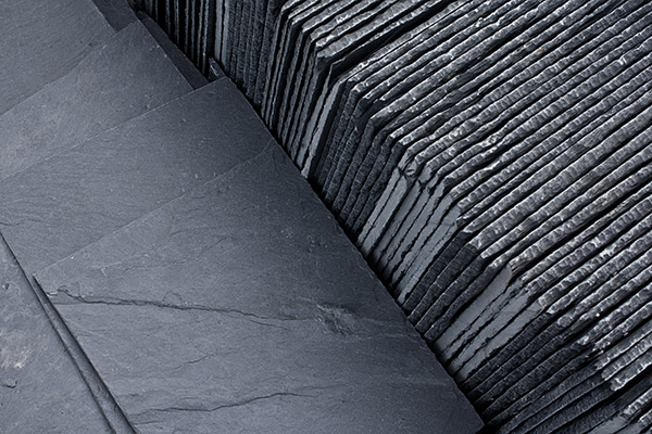 Slate roofing tiles lined up in a row.