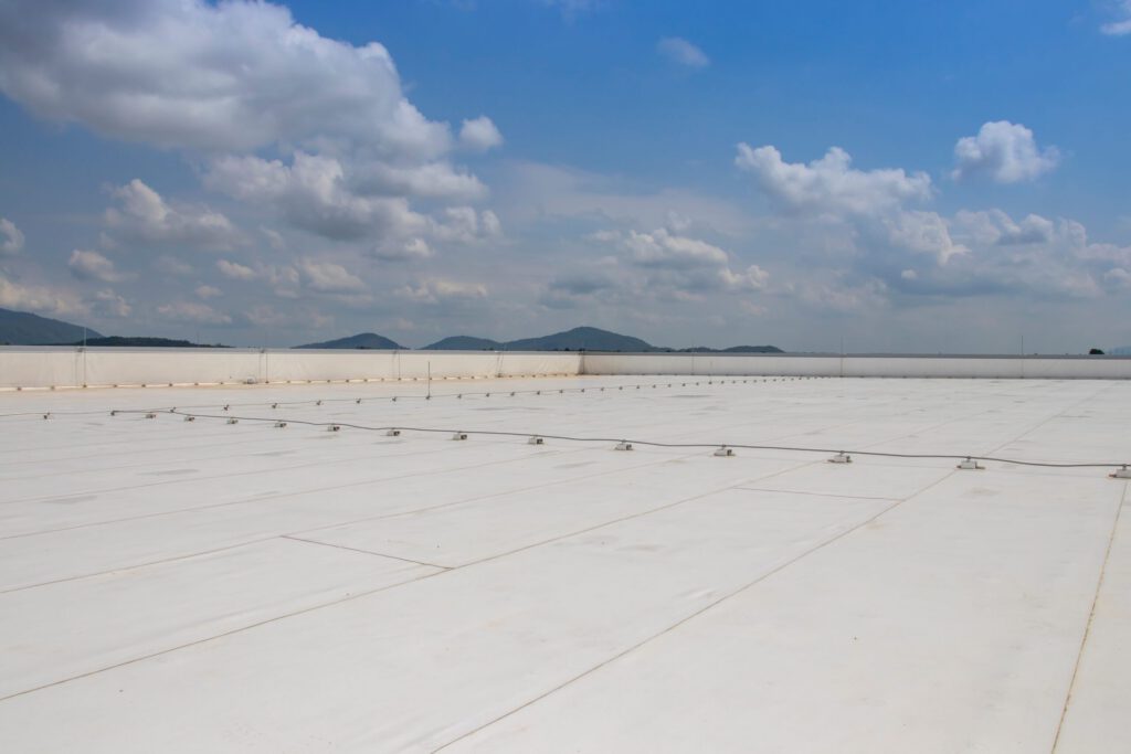 A commercial roof with PVC material on it against a blue sky.