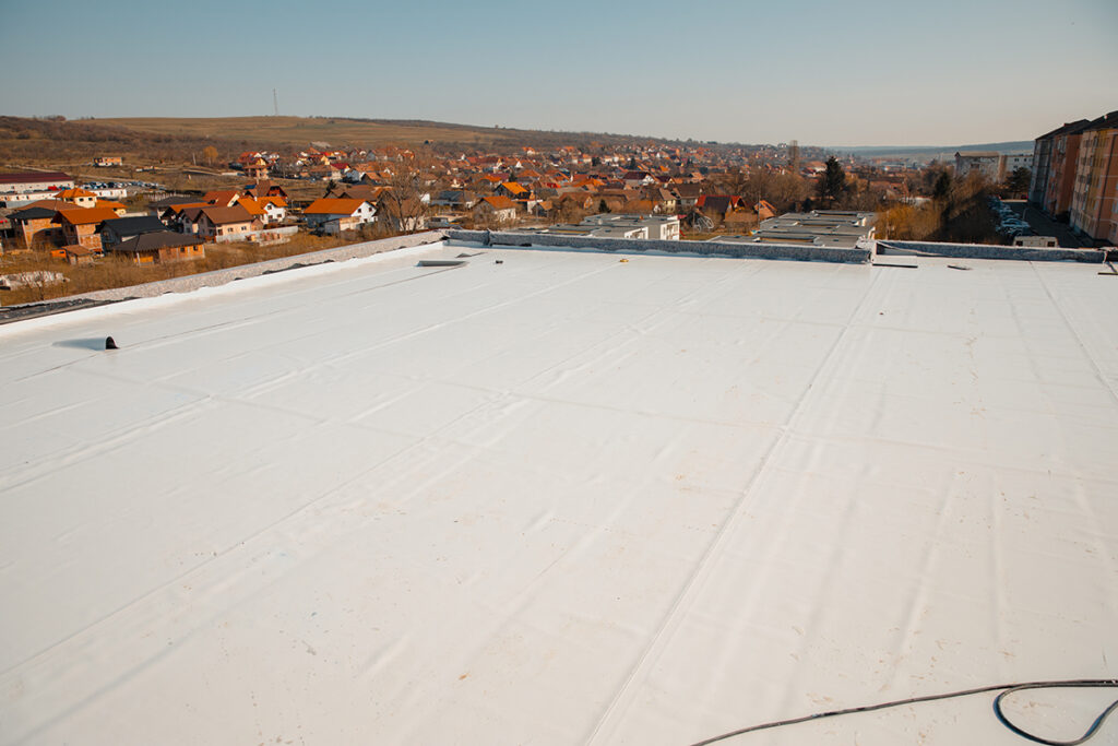 A flat roof with a white reflective PVC membrane.