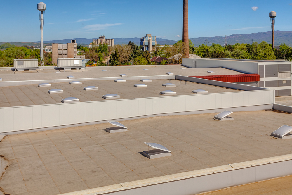 A manufacturing facility with a commercial flat roofing system and exhausts.
